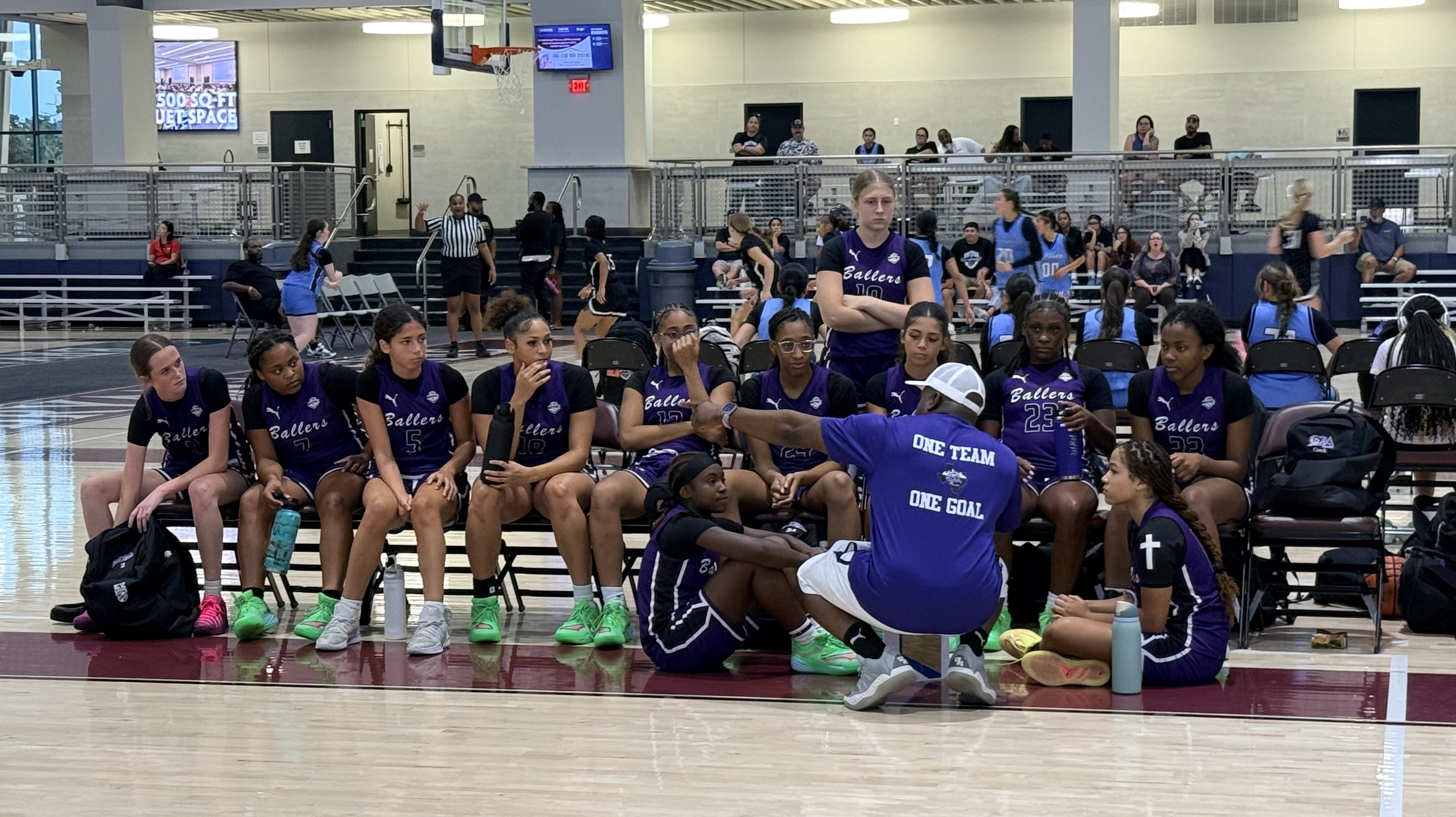 Ballers Ignited coaches teaching players during a game huddle