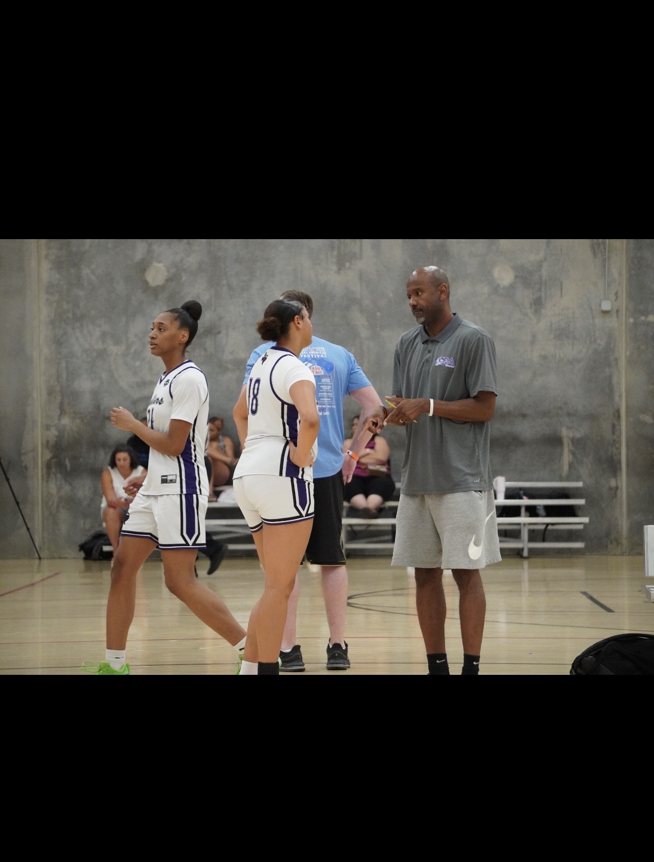 Ballers Ignited coaches teaching players during a game huddle